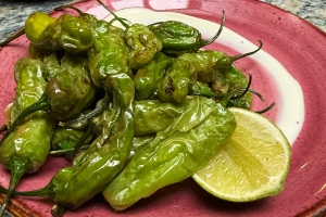 Shishito peppers on a candlelit stone table